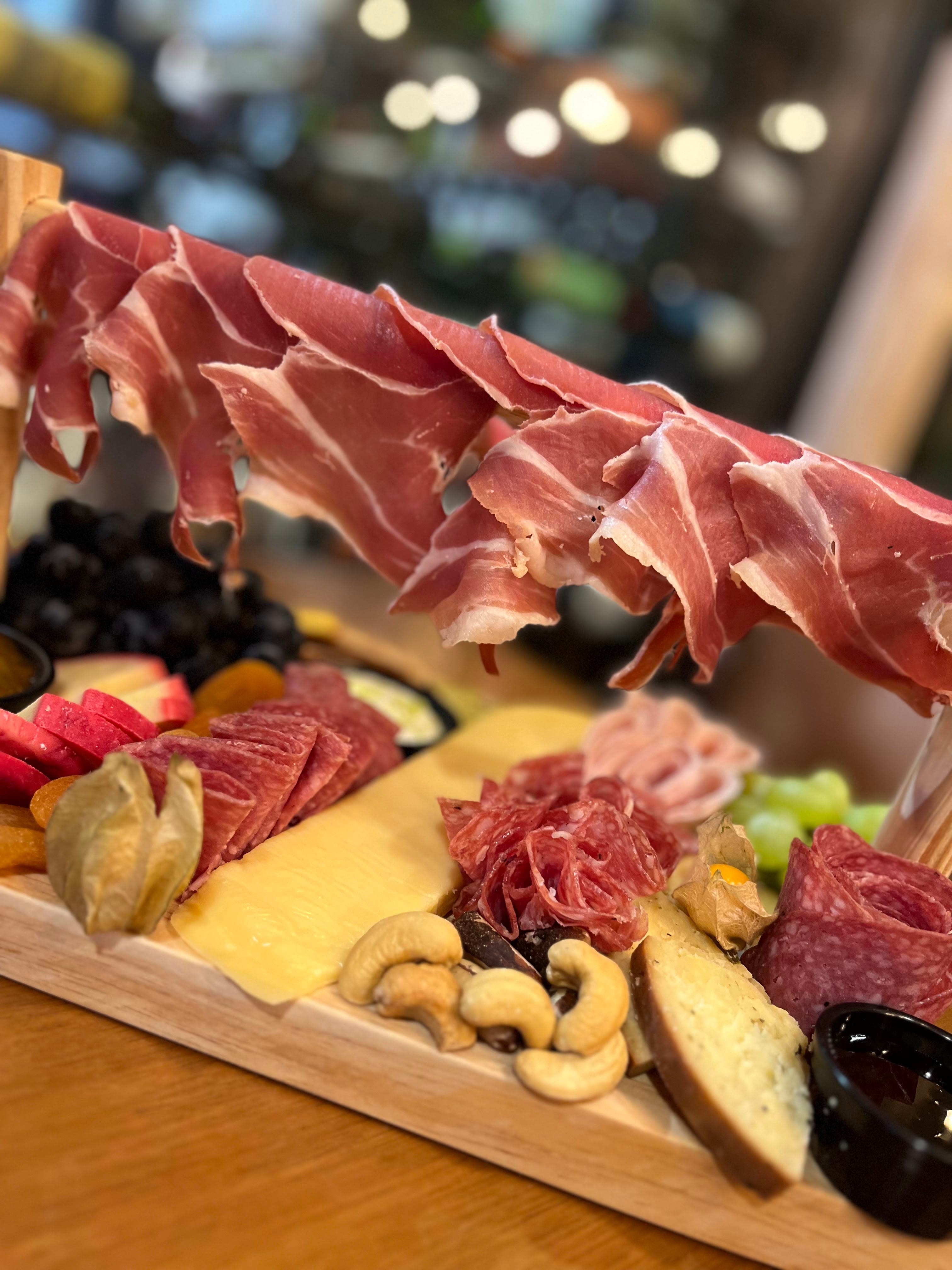 Tábua gourmet com queijos, charcutaria, frutas e castanhas