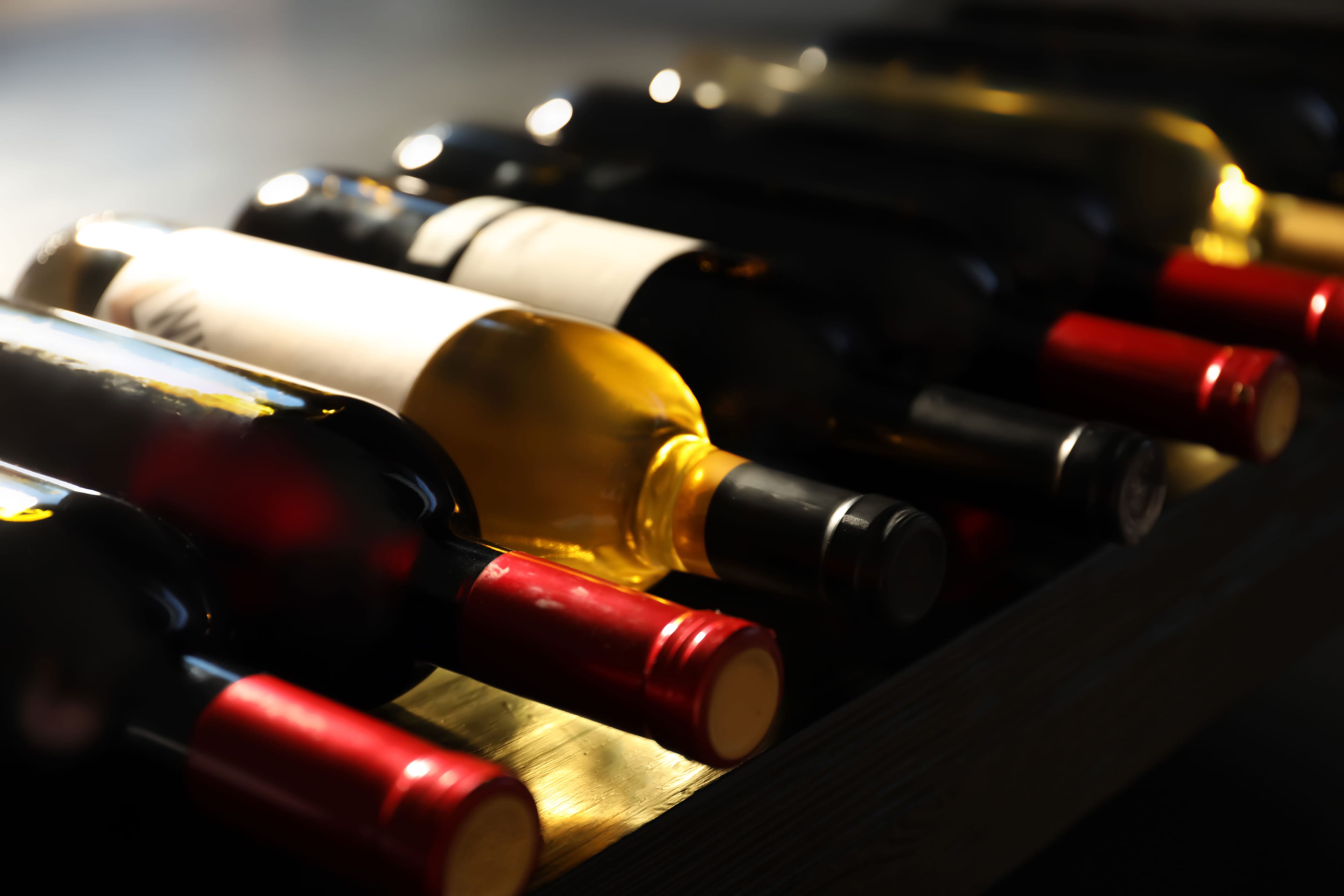 Garrafas de vinho iluminadas em adega escura
