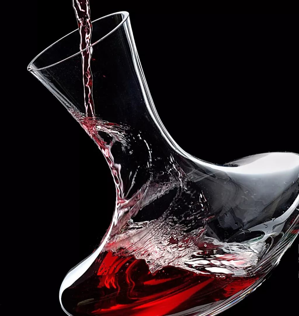 Vinho tinto girando em decantador de cristal, sobre fundo escuro